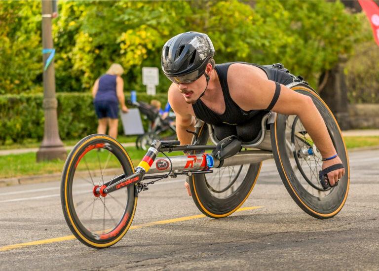 Wheelchair racer on a road race course, adaptive sports photography