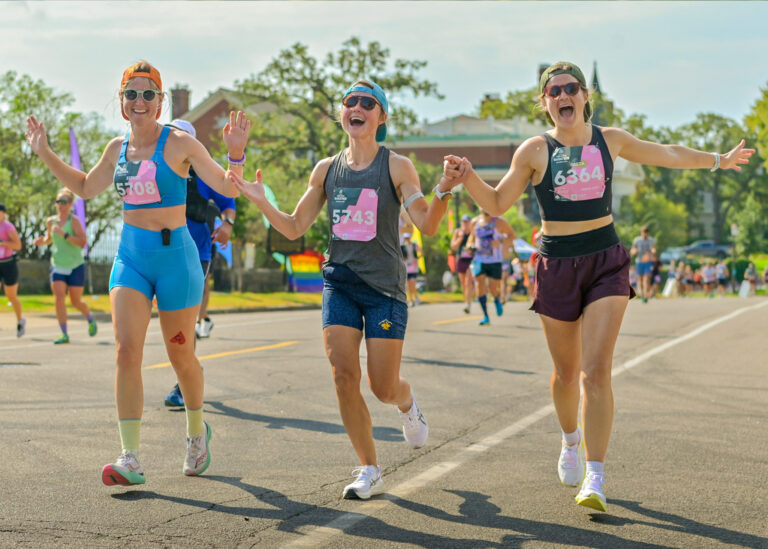 Three women running together during a road race