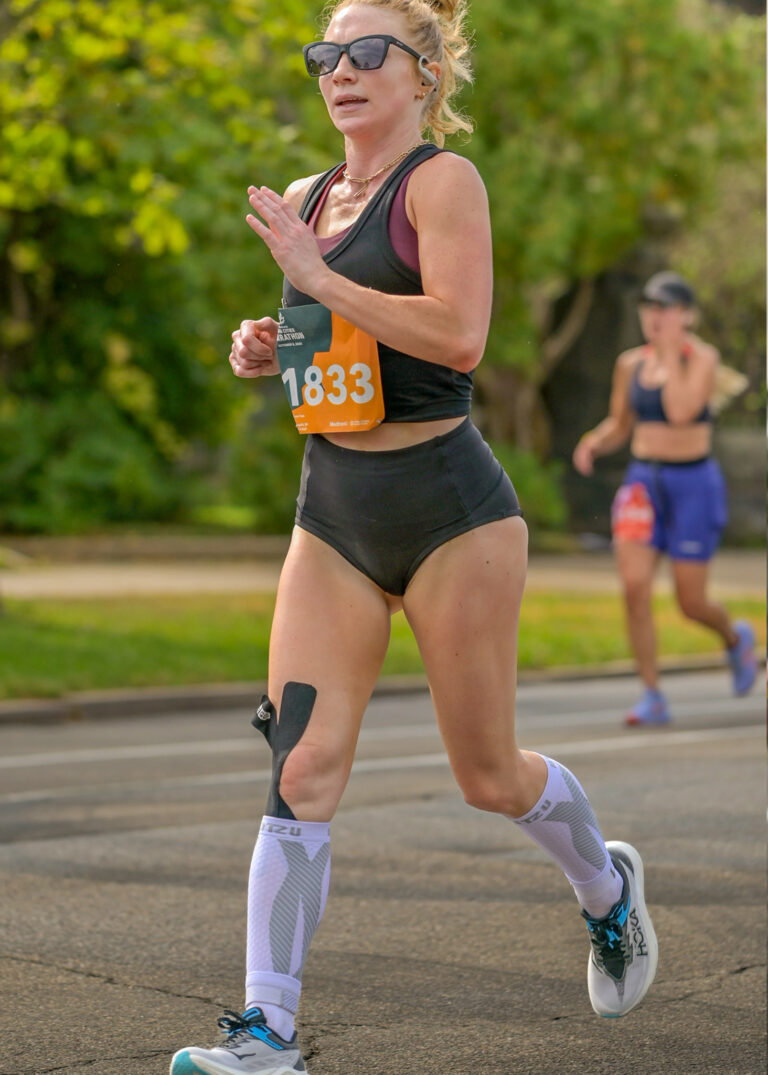 Runner mid-stride in a road race, running photography