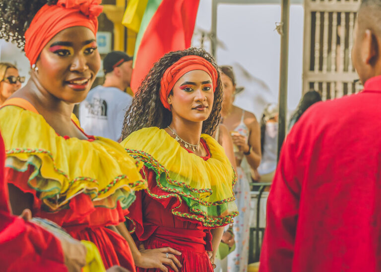 Two dancers in matching yellow and red dresses at a street festival