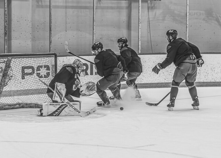 Hockey players and goalie in a scramble in front of the net