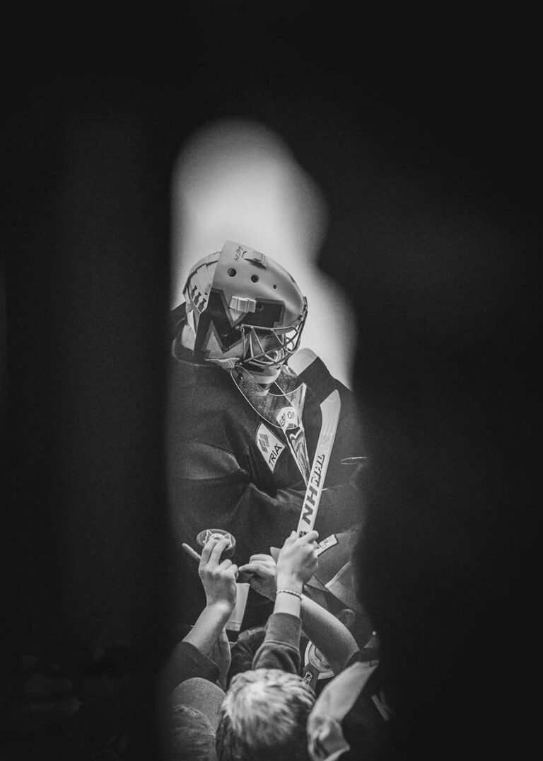 Hockey goalie wearing a mask in black and white
