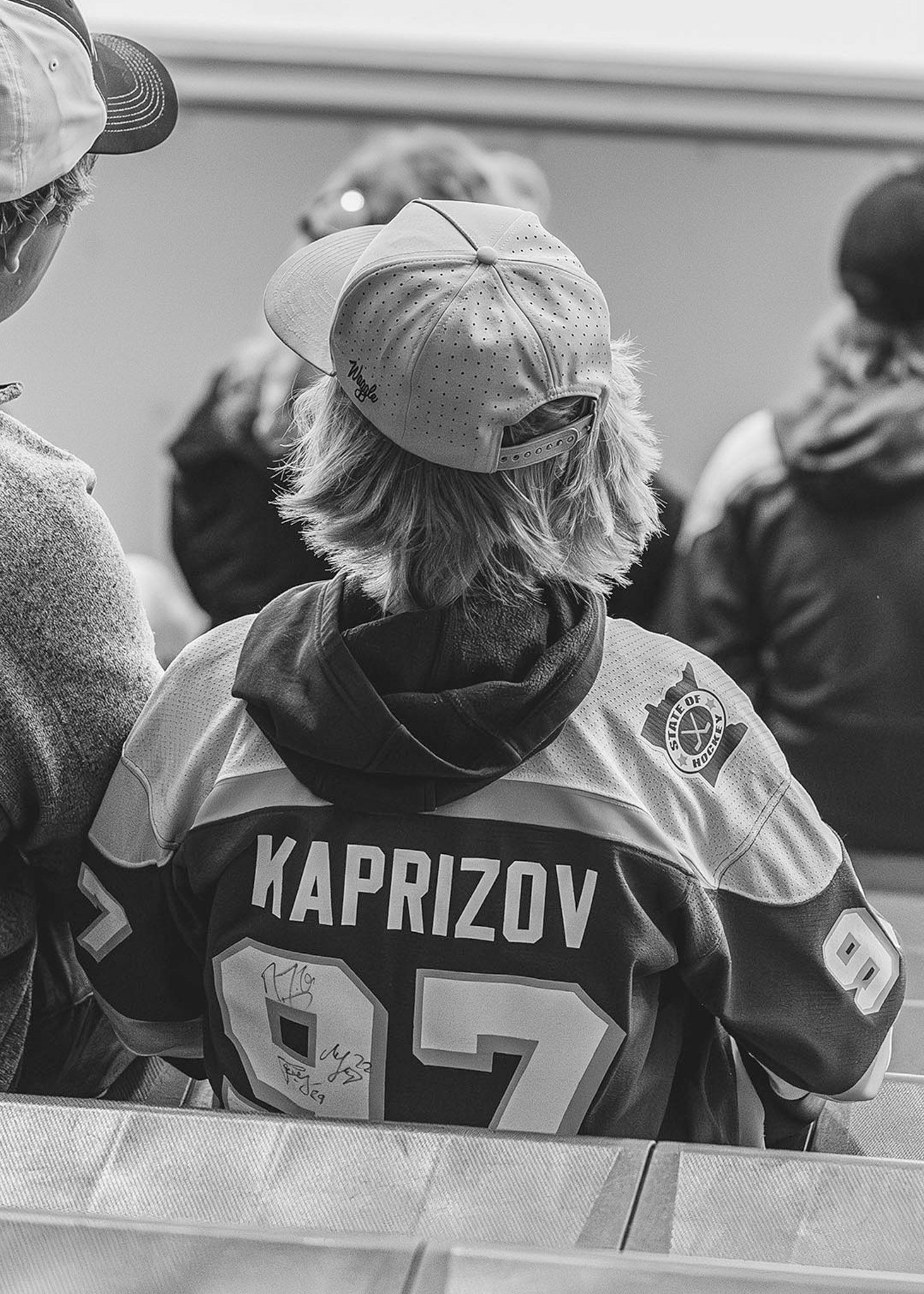 Hockey fan in a team jersey seen from behind in black and white