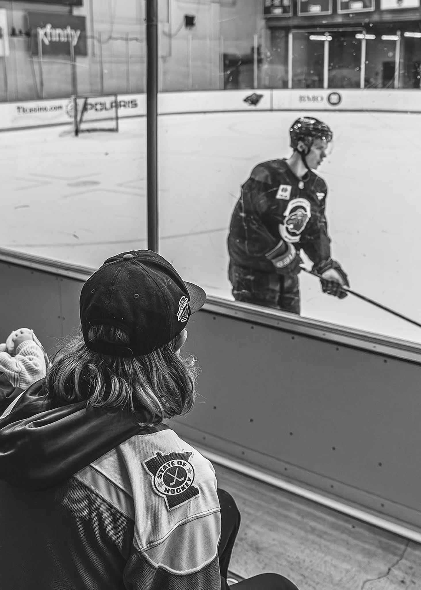 Hockey player at the glass in black and white with a fan watching