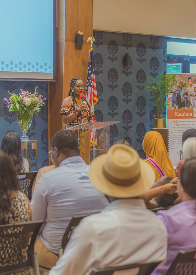 Speaker with a microphone at a podium with an American flag behind at a corporate event