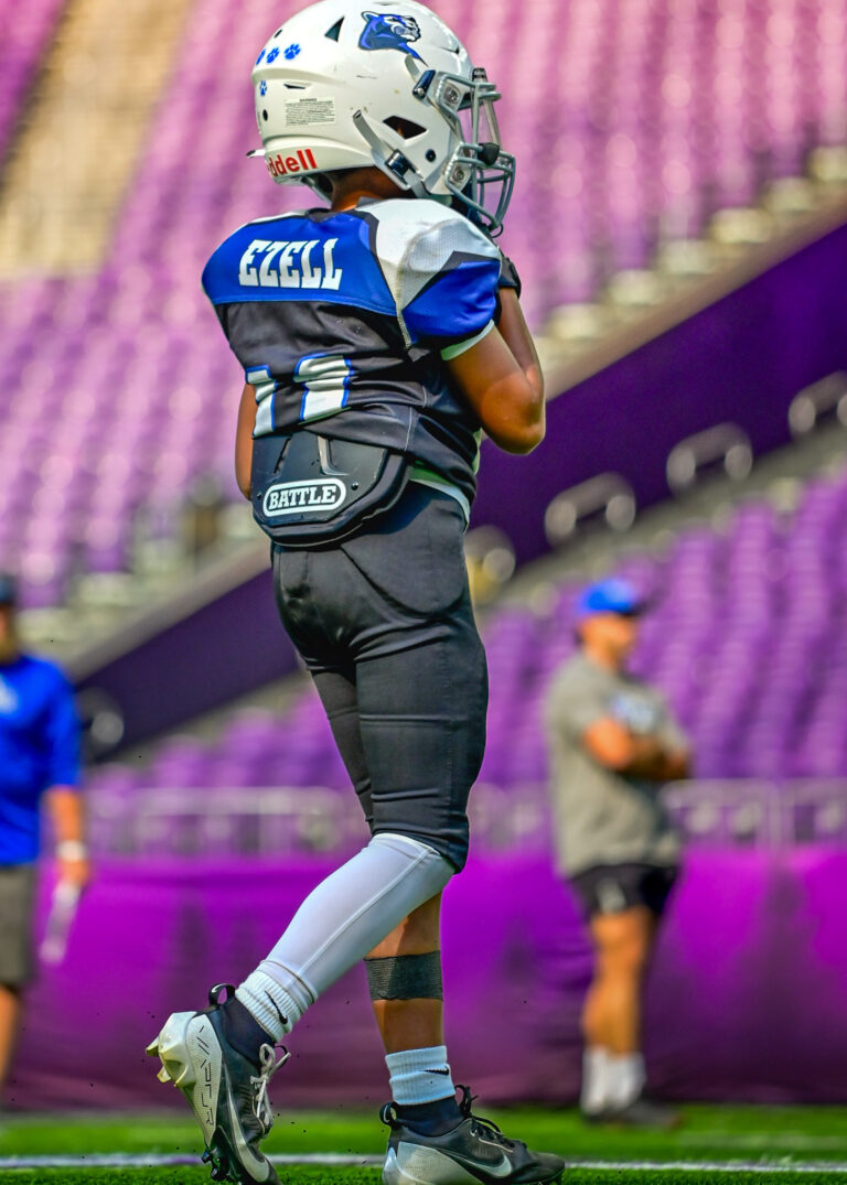 Youth football player in a blue jersey in a stadium, sport photography Minneapolis