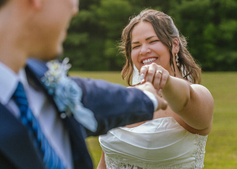 Smiling bride reaching toward the groom