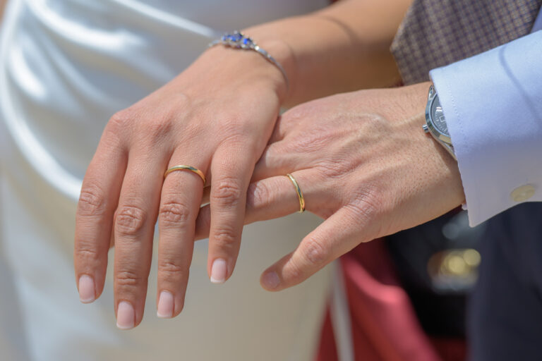 Bride and groom's hands together showing their wedding rings